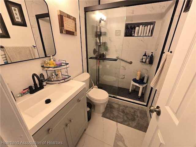 bathroom featuring vanity, toilet, a shower with shower door, and tile patterned flooring