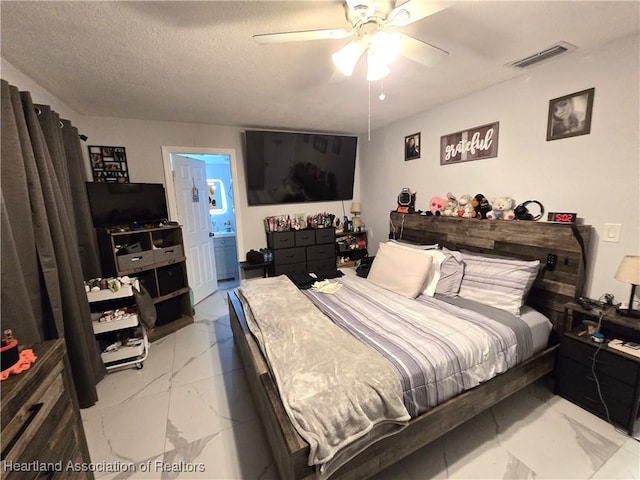 bedroom featuring ensuite bathroom, a textured ceiling, and ceiling fan