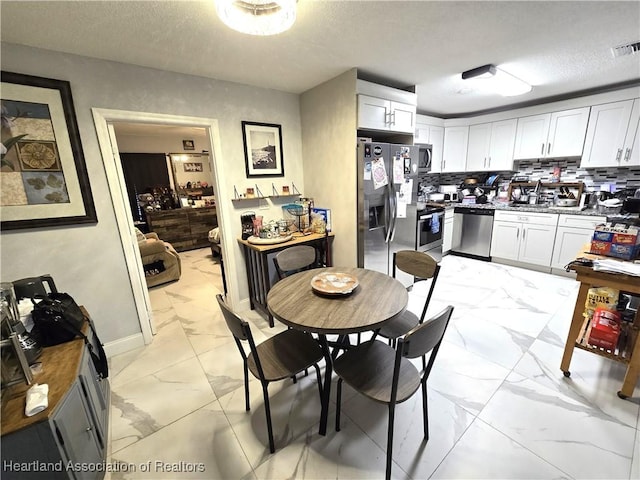 dining space with sink and a textured ceiling