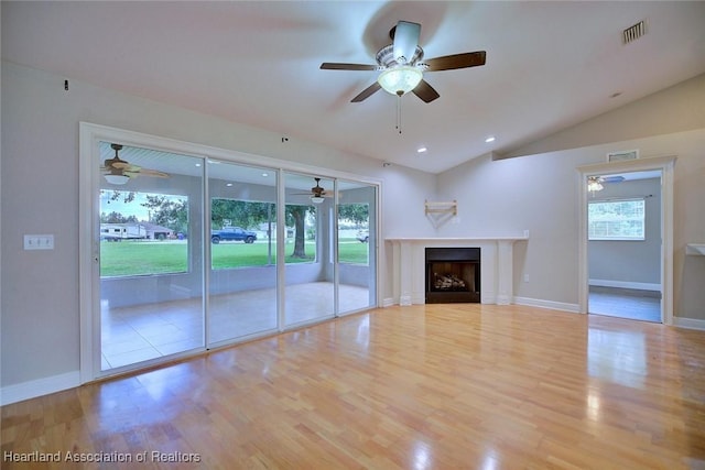1465 Berwin Ave, Avon Park, FL 33825 - unfurnished living room featuring ceiling fan, wood finished floors, vaulted ceiling, and a fireplace