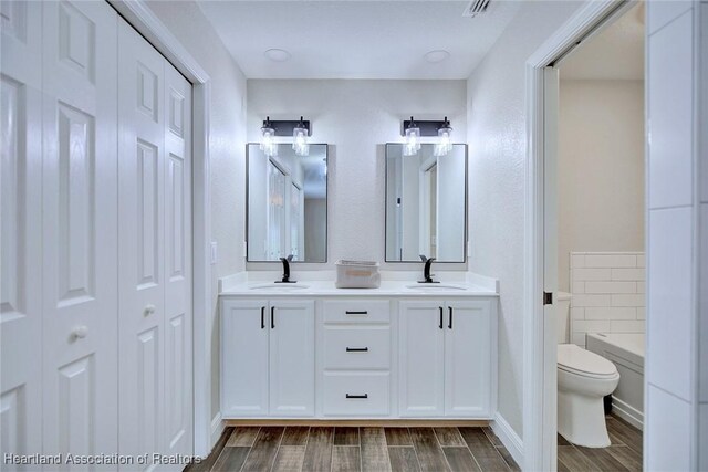 1465 Berwin Ave, Avon Park, FL 33825 - bathroom with a closet, double vanity, wood finish floors, and a tub