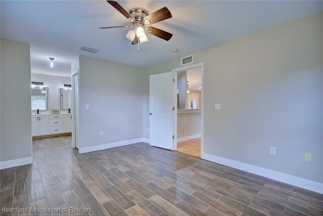 1465 Berwin Ave, Avon Park, FL 33825 - unfurnished bedroom featuring dark wood-style floors, connected bathroom, and a ceiling fan