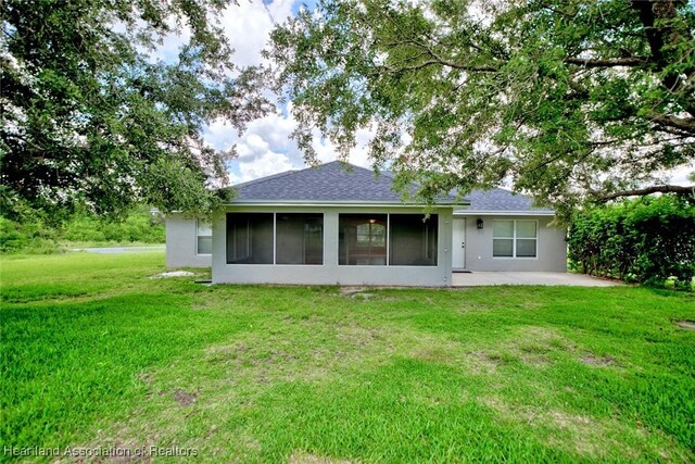1465 Berwin Ave, Avon Park, FL 33825 - rear view of property featuring a lawn, a patio area, stucco siding, and a sunroom
