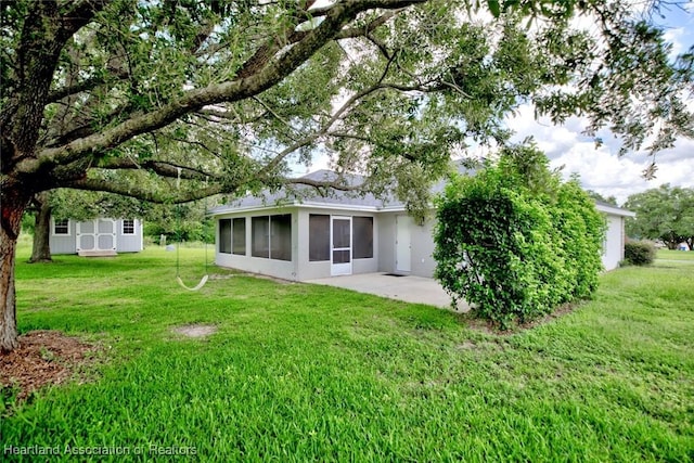 1465 Berwin Ave, Avon Park, FL 33825 - rear view of property featuring a sunroom, a shed, a lawn, and a patio area
