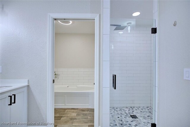 1465 Berwin Ave, Avon Park, FL 33825 - bathroom with a shower stall, a bath, vanity, and wood finished floors