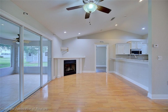 1465 Berwin Ave, Avon Park, FL 33825 - unfurnished living room featuring ceiling fan, light wood-style floors, lofted ceiling, recessed lighting, and a fireplace