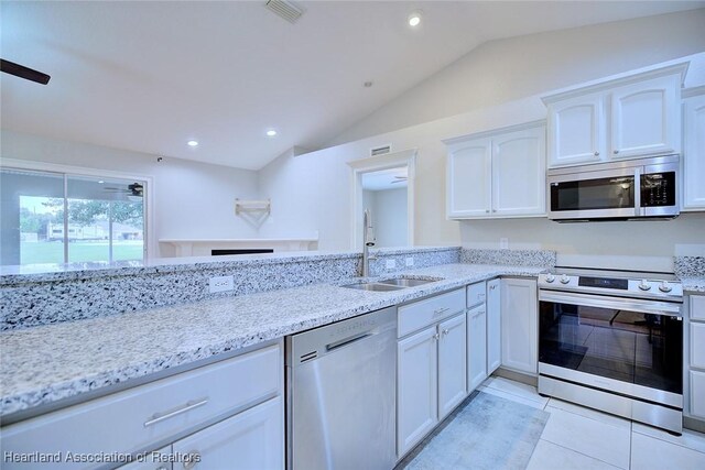 1465 Berwin Ave, Avon Park, FL 33825 - kitchen featuring stainless steel appliances, vaulted ceiling, light stone countertops, white cabinetry, and light tile patterned flooring