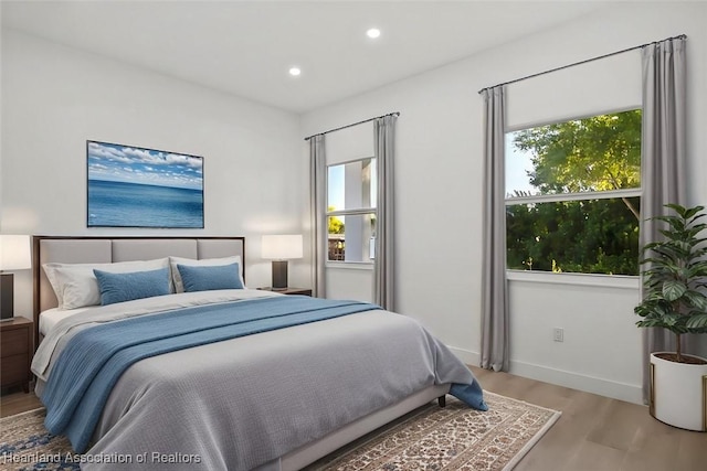 bedroom featuring multiple windows and light hardwood / wood-style flooring