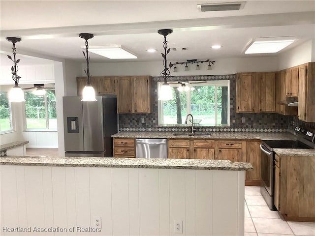 136 Hallmark Ave, Lake Placid, FL 33852 - kitchen featuring stainless steel appliances, a sink, brown cabinetry, backsplash, and recessed lighting