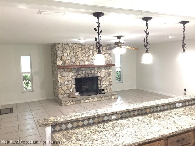 136 Hallmark Ave, Lake Placid, FL 33852 - unfurnished living room featuring tile patterned floors, baseboards, a stone fireplace, and ceiling fan