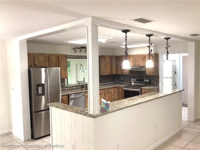 136 Hallmark Ave, Lake Placid, FL 33852 - kitchen with appliances with stainless steel finishes, brown cabinets, backsplash, and light tile patterned flooring