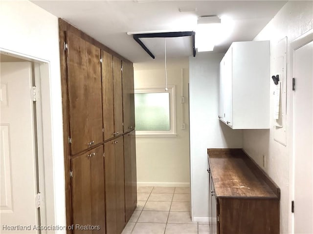 136 Hallmark Ave, Lake Placid, FL 33852 - kitchen featuring light tile patterned floors, dark countertops, baseboards, and brown cabinets