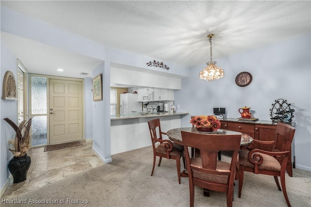 dining space with light colored carpet and a notable chandelier