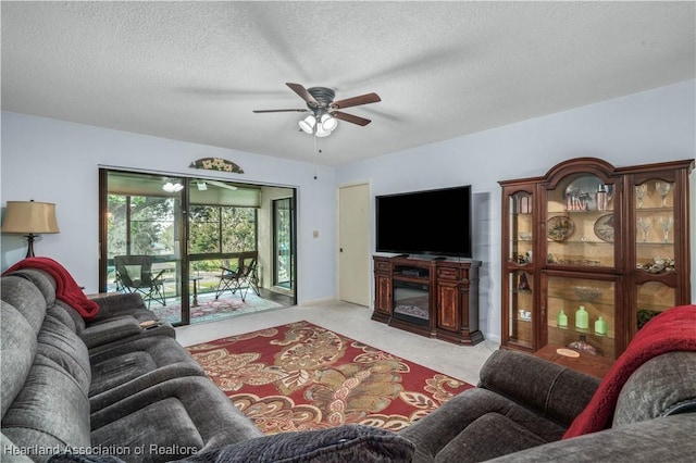 carpeted living room with a textured ceiling and ceiling fan