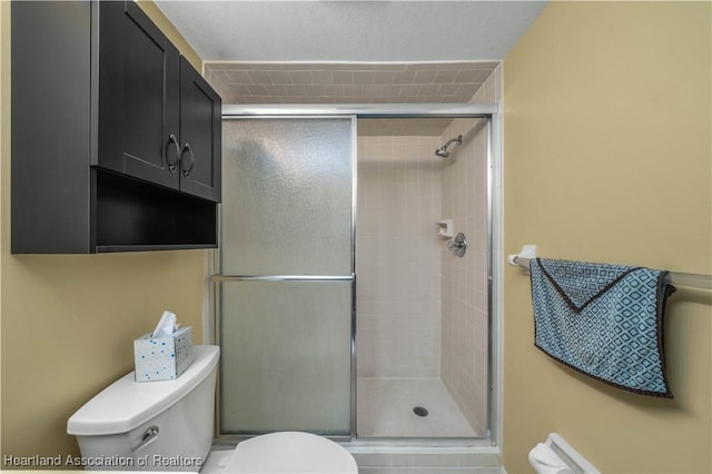 bathroom with toilet and an enclosed shower