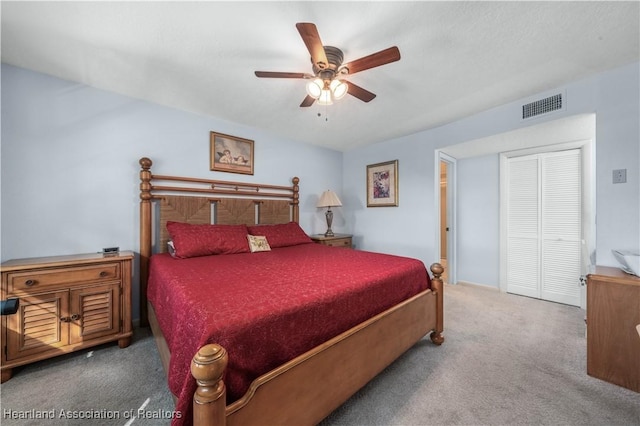 bedroom with ceiling fan, carpet floors, and a closet