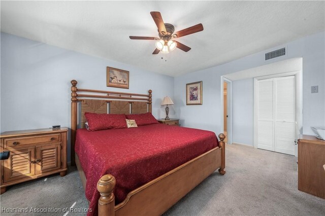 bedroom with ceiling fan, carpet floors, and a closet