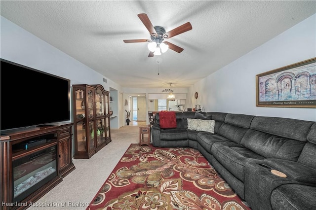 carpeted living room with ceiling fan and a textured ceiling