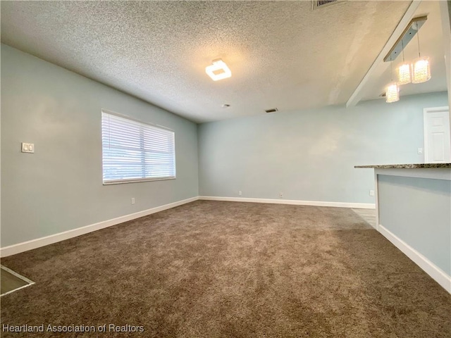 carpeted spare room featuring a textured ceiling