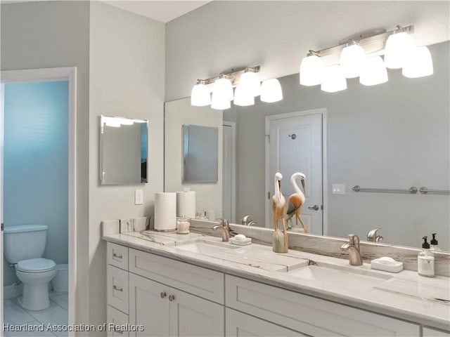 bathroom featuring tile patterned flooring, vanity, and toilet