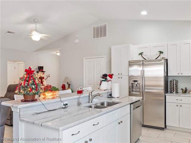 kitchen featuring sink, vaulted ceiling, ceiling fan, an island with sink, and stainless steel appliances