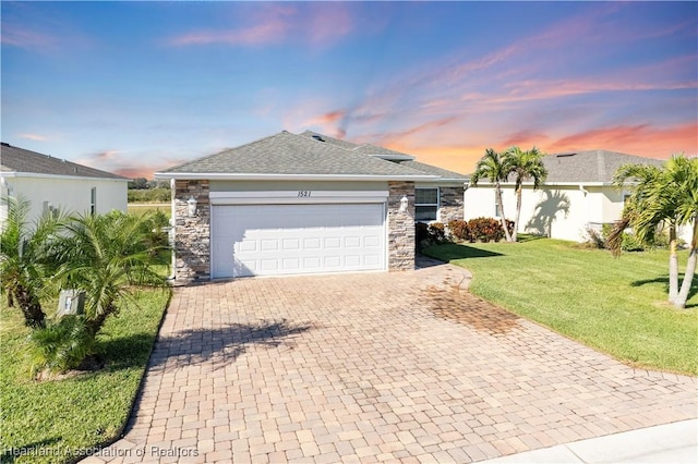 ranch-style home with a garage and a lawn