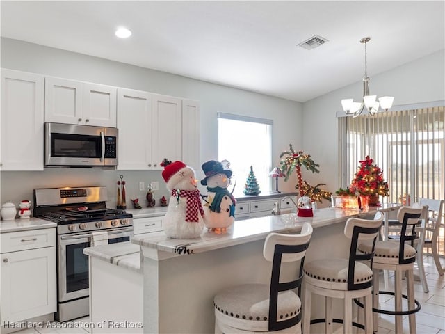 kitchen featuring white cabinetry, plenty of natural light, an island with sink, and stainless steel appliances