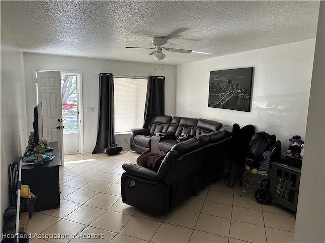 living room with ceiling fan, light tile patterned floors, and a textured ceiling