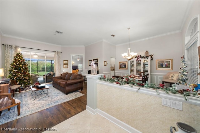 living room with hardwood / wood-style floors, a chandelier, and ornamental molding