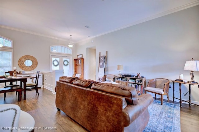 living area with baseboards, wood finished floors, and crown molding