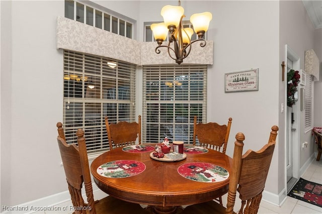 tiled dining area featuring a towering ceiling and a chandelier