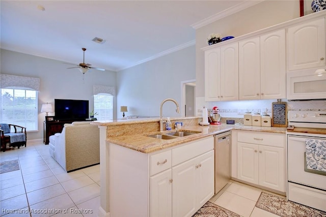 kitchen with white appliances, a sink, a peninsula, and open floor plan