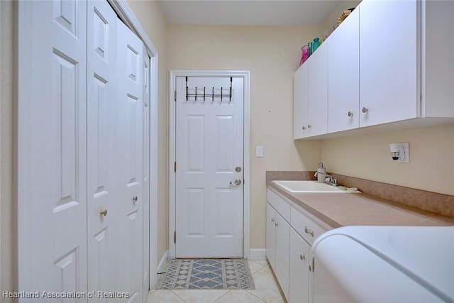 washroom with cabinet space, baseboards, a sink, and light tile patterned flooring