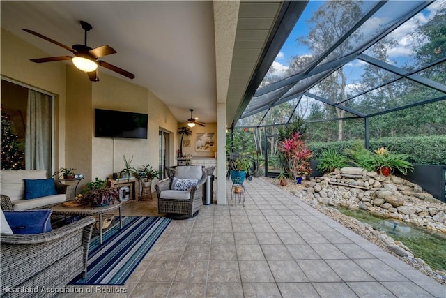 view of patio / terrace featuring an outdoor hangout area, glass enclosure, and ceiling fan