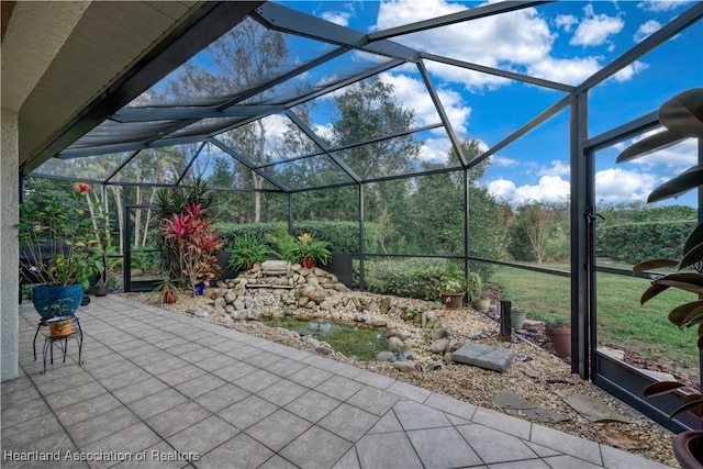 view of patio featuring glass enclosure