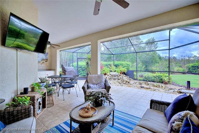 view of patio / terrace featuring a ceiling fan, outdoor dining area, glass enclosure, and an outdoor hangout area