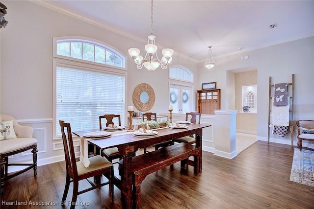 dining area with a wainscoted wall, plenty of natural light, dark wood finished floors, and crown molding