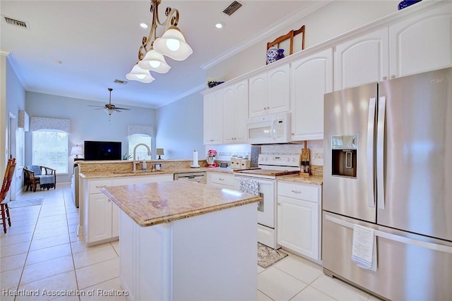 kitchen featuring visible vents, white appliances, decorative light fixtures, and a peninsula