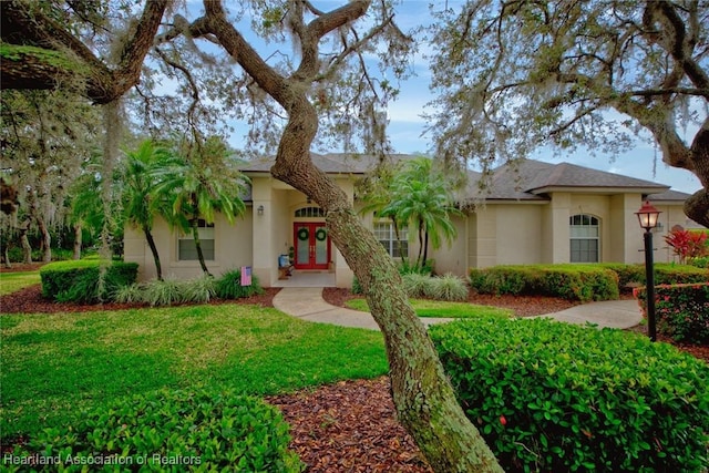 view of front of home featuring french doors, a front lawn, and stucco siding