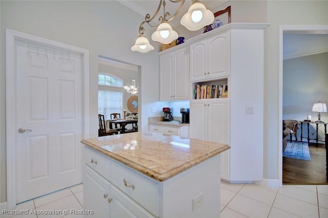 kitchen featuring ornamental molding, a center island, white cabinetry, and light tile patterned floors