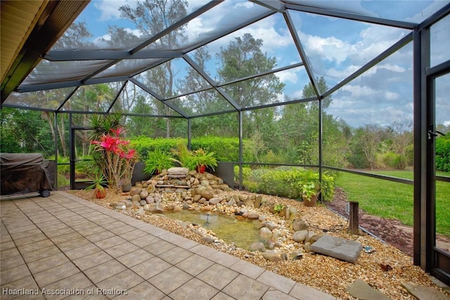 view of patio featuring glass enclosure