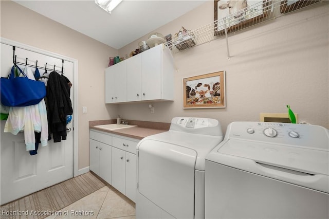 washroom featuring light tile patterned flooring, cabinets, separate washer and dryer, and sink