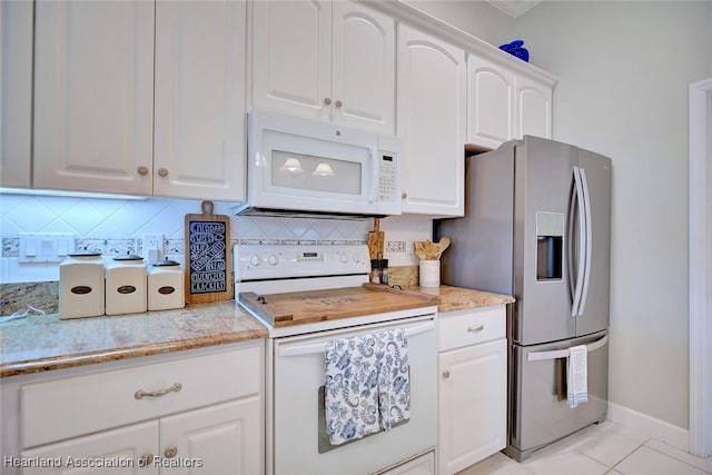 kitchen featuring white appliances, light tile patterned floors, baseboards, white cabinets, and decorative backsplash