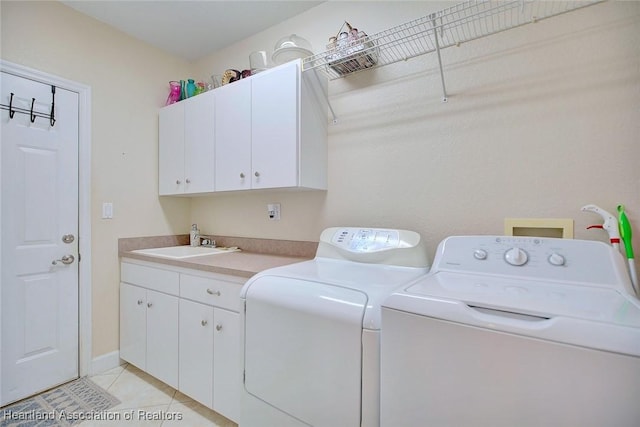 laundry area with light tile patterned flooring, a sink, cabinet space, and washer and dryer