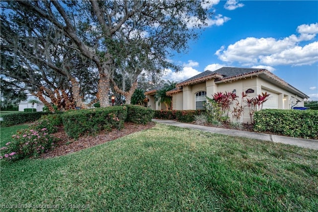 view of front of property featuring a front lawn and a garage