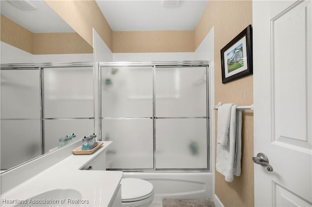 full bathroom with vanity, toilet, and enclosed tub / shower combo