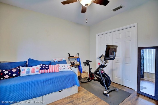 bedroom featuring a closet, visible vents, ceiling fan, and wood finished floors