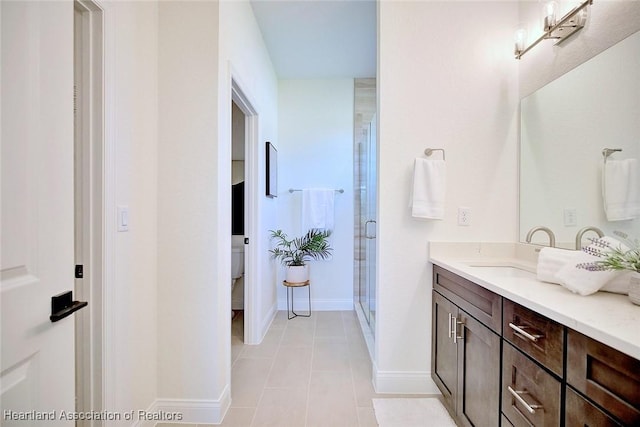 bathroom with vanity, a shower with shower door, toilet, and tile patterned flooring