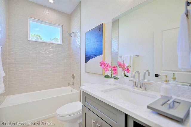 full bathroom with toilet, tile patterned floors, tiled shower / bath, and vanity