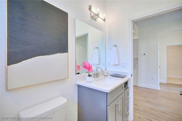 bathroom featuring toilet, hardwood / wood-style floors, and vanity